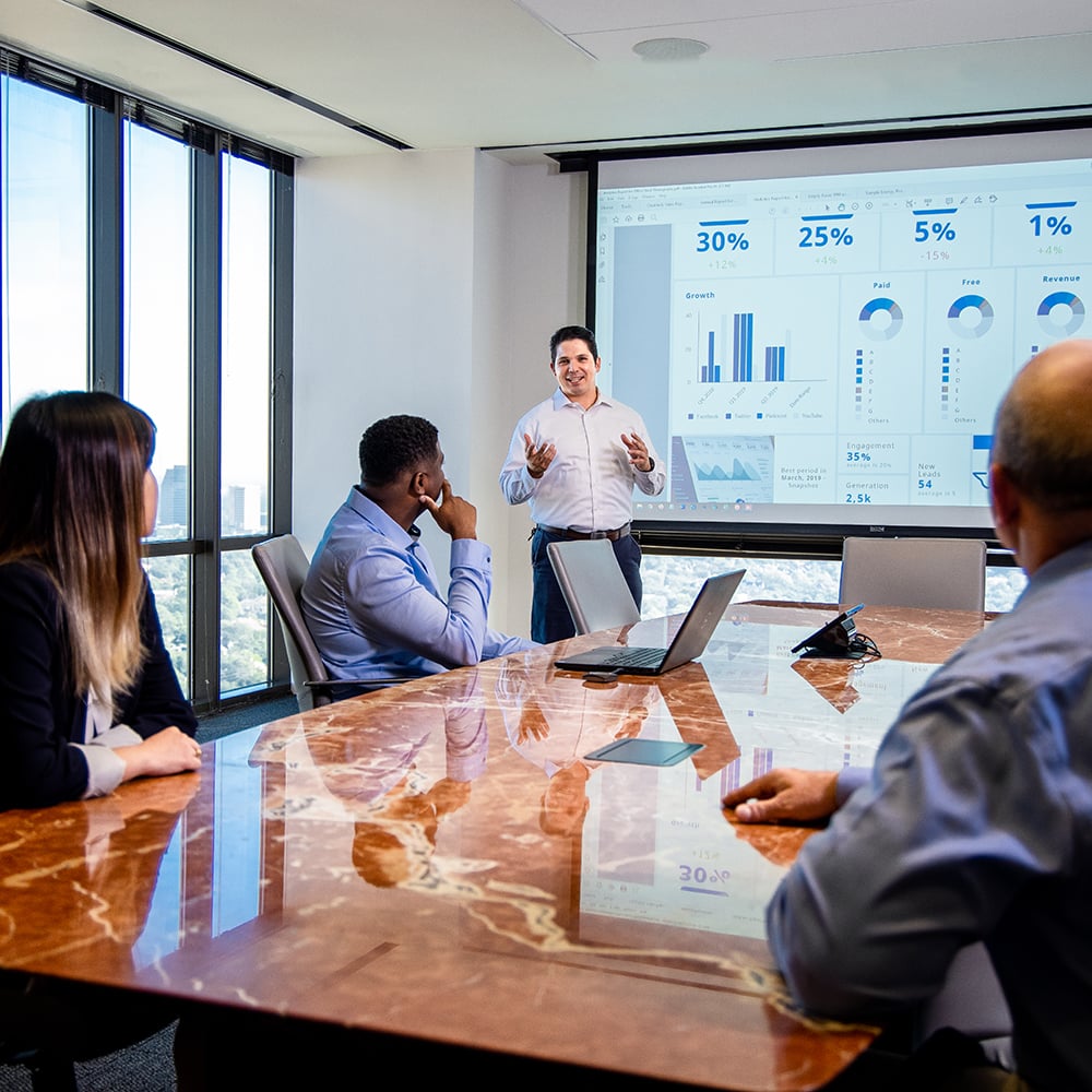 Carlos Presenting in Conference Room_04881 - NFP 1000x1000